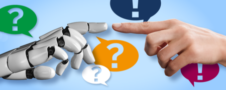 Der Zeigefinger einer Roboterhand sowie einer menschlichen Hand berühren sich. Um die Hände herum befinden sich Sprechblasen mit Frage- und Ausrufezeichen.  - Link auf: Künstliche Intelligenz (KI)