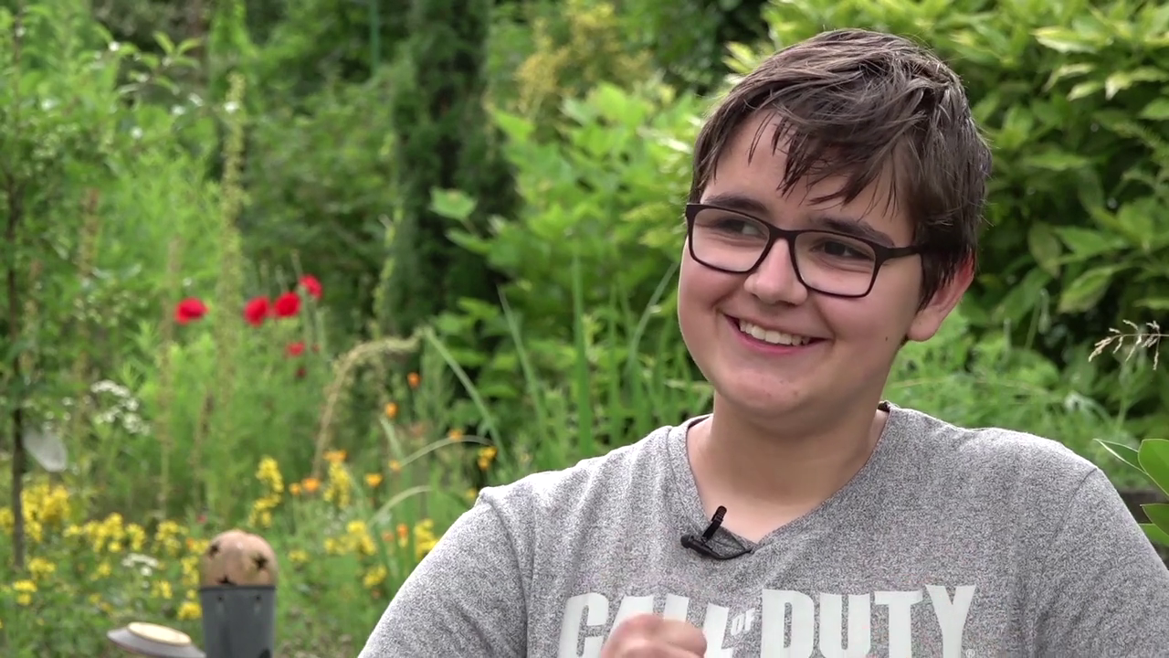 Man sieht einen Jungen, der interviewt wird
